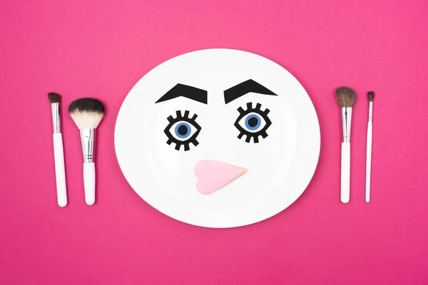 Pincéis de maquiagem e rosto de papel — Fotografia de Stock