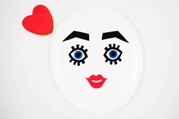 Paper face with makeup on plate — Stock Photo