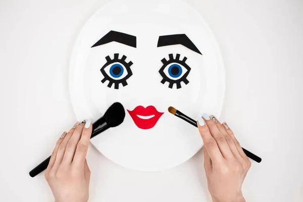 Paper face with makeup on plate — Stock Photo