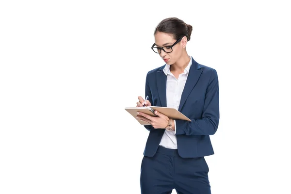 Businesswoman writing in diary — Stock Photo