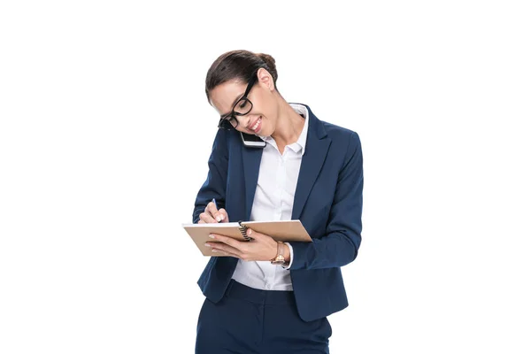 Businesswoman writing in notepad — Stock Photo