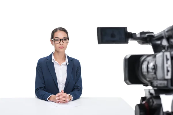 Presentador de noticias sentado frente a la cámara - foto de stock