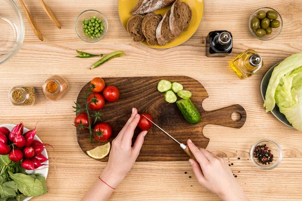 Woman cutting cherry tomatoes — Stock Photo