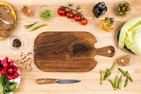 Planche à découper en bois et légumes — Photo de stock
