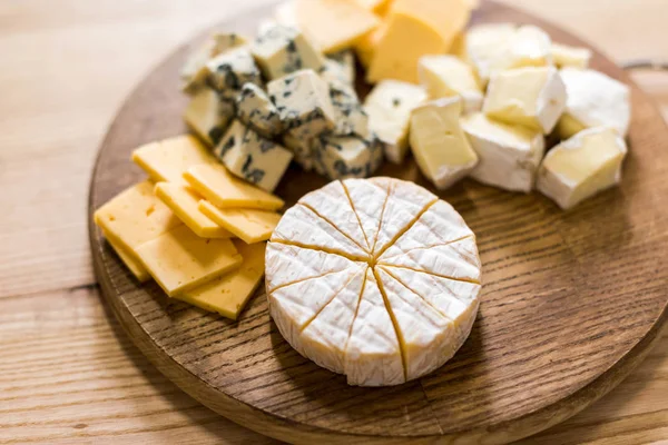 Variety of cheese kinds on wooden board — Stock Photo