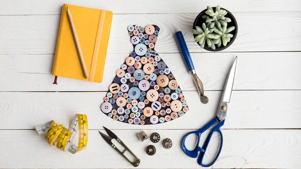 Dress made of buttons and tailoring items — Stock Photo