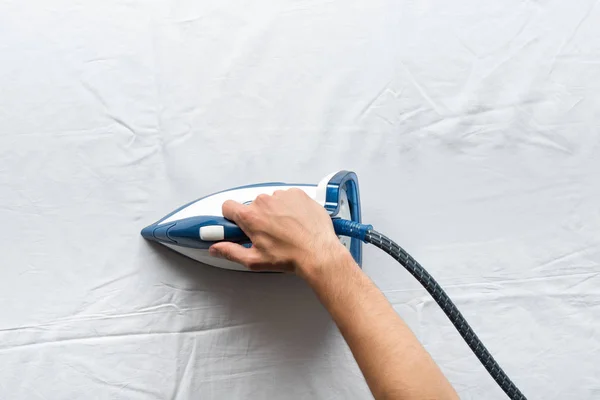 Man ironing bed sheets — Stock Photo