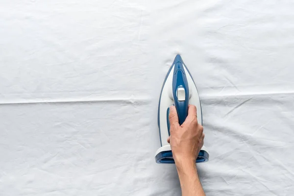 Man ironing bed sheets — Stock Photo