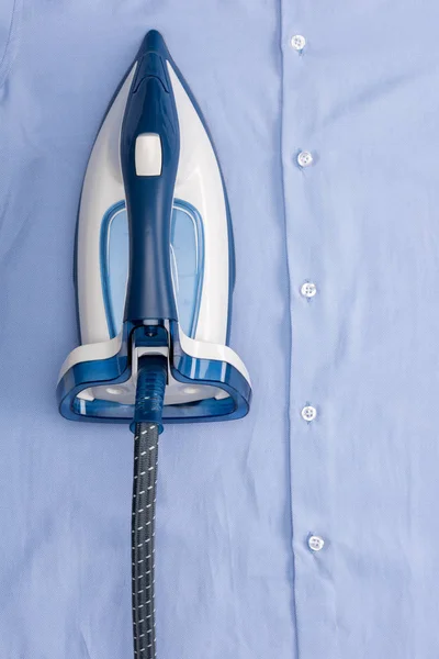 Iron on blue shirt — Stock Photo