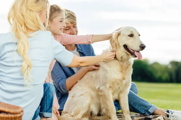 Glückliche Familie mit Hund im Park — Stockfoto