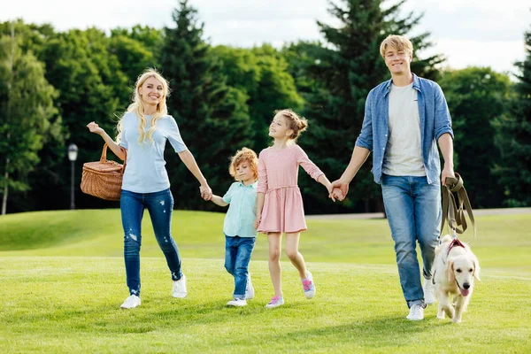 Famiglia con cane che cammina nel parco — Foto stock