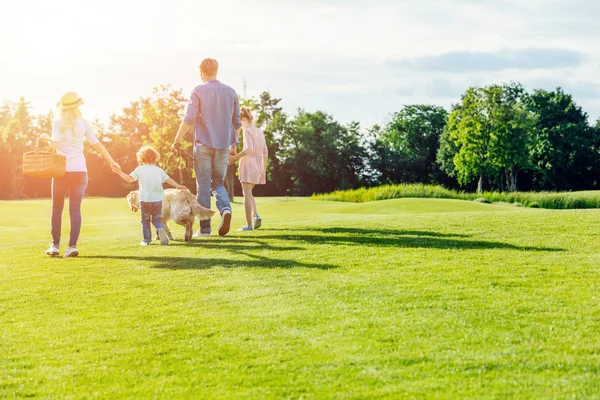 Famiglia con cane che cammina nel parco — Foto stock