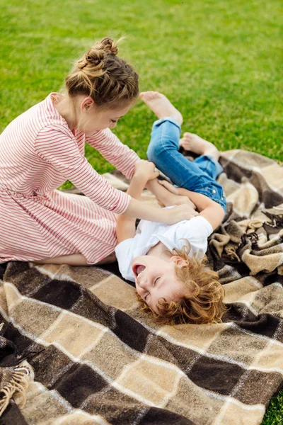 Siblings having fun on plaid at park — Stock Photo