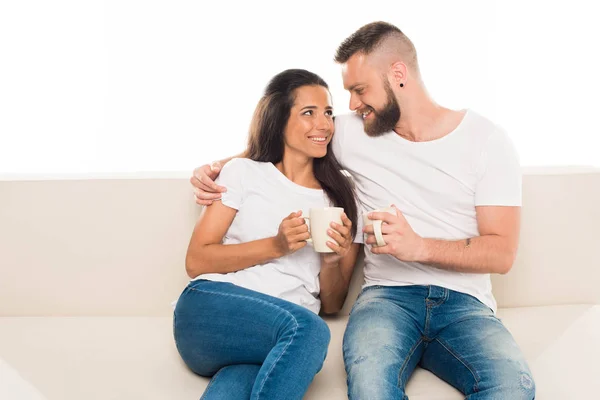 Pareja atractiva en el sofá con café - foto de stock