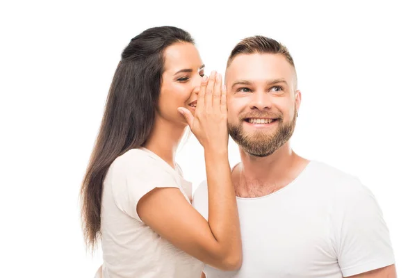 Young woman whispering to boyfriends ear — Stock Photo