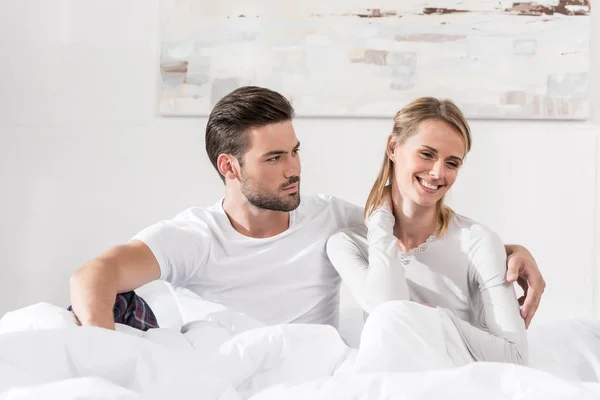 Pareja abrazándose en la cama - foto de stock