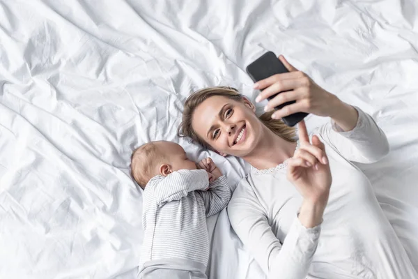 Madre tomando selfie con el bebé - foto de stock