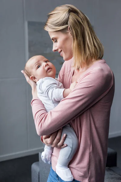 Madre sosteniendo a su hijo - foto de stock