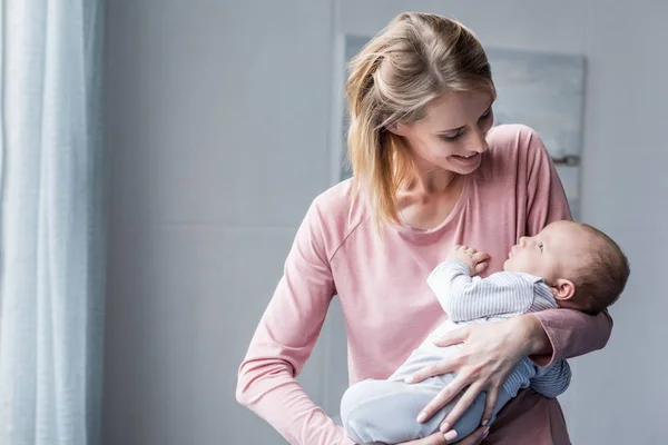 Madre sosteniendo a su hijo - foto de stock