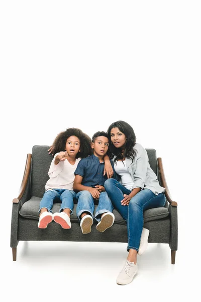 Shocked mother with kids on sofa — Stock Photo