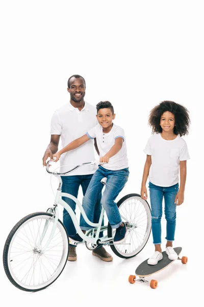 Famille afro-américaine avec vélo et planche à roulettes — Photo de stock