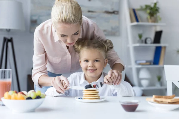 Mother and daughter eating pancakes — Stock Photo