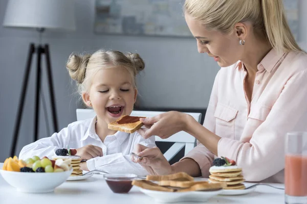 Madre e hija desayunando - foto de stock