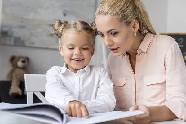 Mother and daughter reading book — Stock Photo