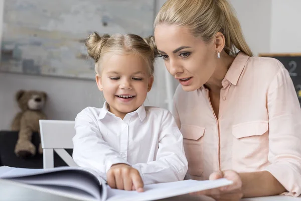 Mère et fille lisant le livre — Photo de stock