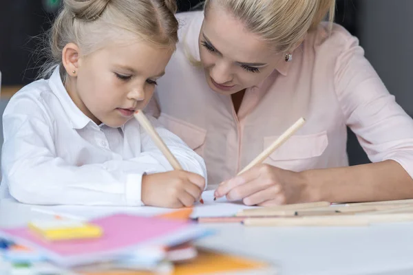 Madre e hija dibujando con lápices - foto de stock