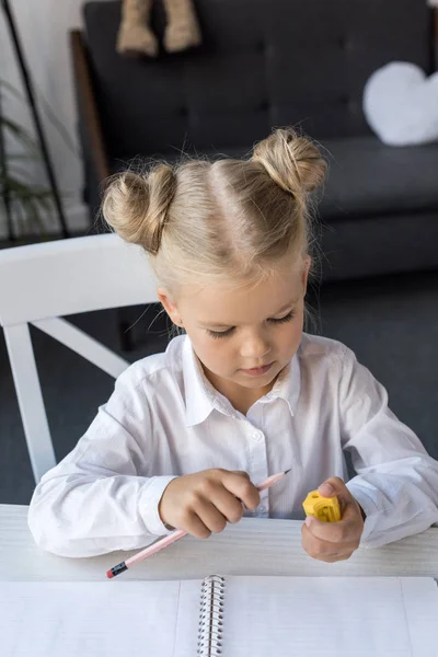 Child sharpening pencil — Stock Photo