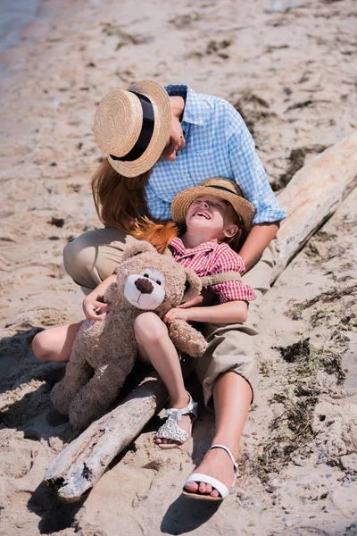 Mère et fille avec ours en peluche sur la plage — Photo de stock