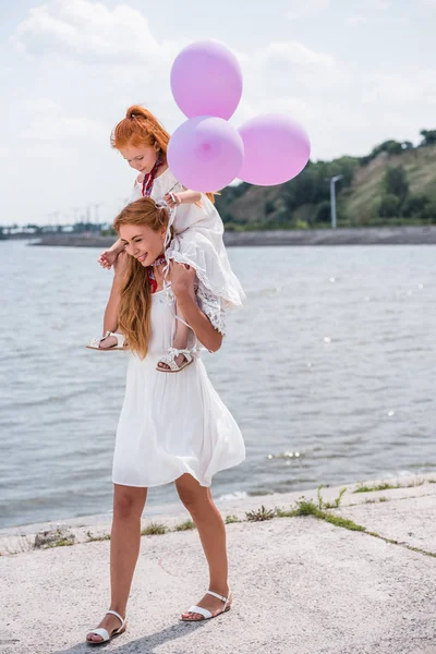 Mother and daughter with balloons — Stock Photo