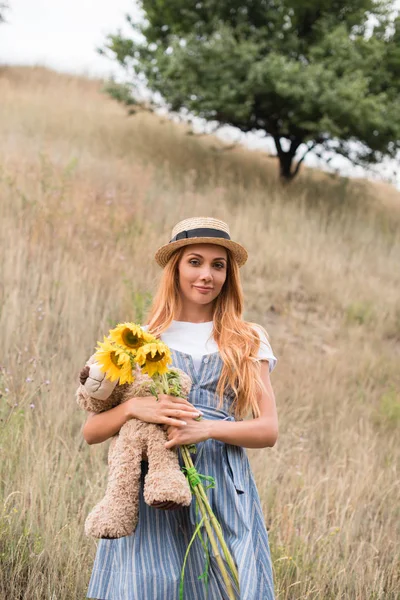 Chica con osito de peluche y girasoles - foto de stock