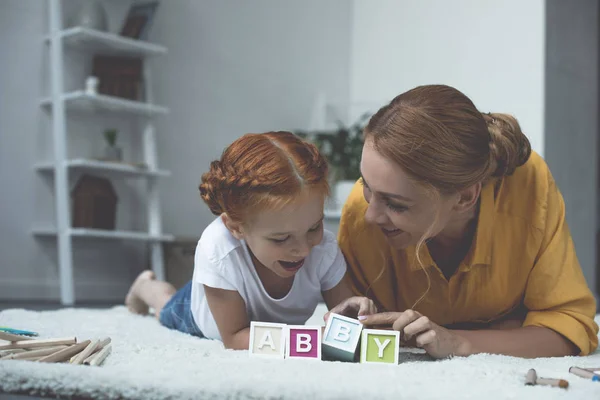 Мать и дочь играют с кубиками букв — стоковое фото