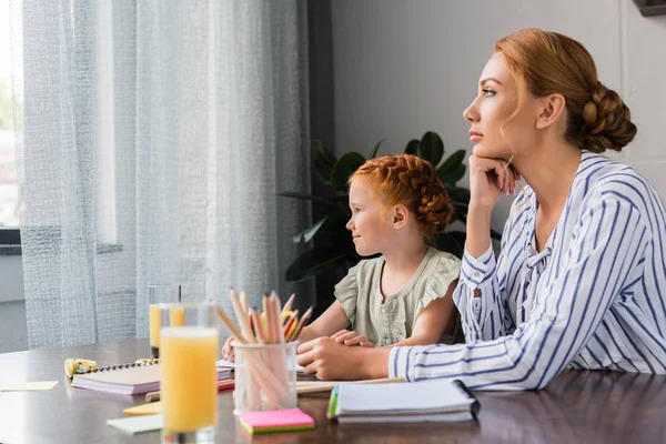 Madre e hija mirando a la ventana - foto de stock