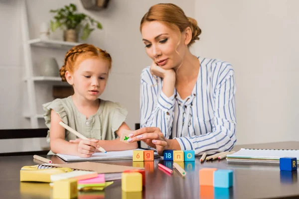 Mère et fille apprendre les mathématiques avec des cubes — Photo de stock