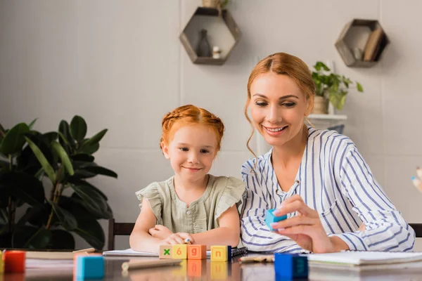 Mother and daughter learning with letter cubes — Stock Photo