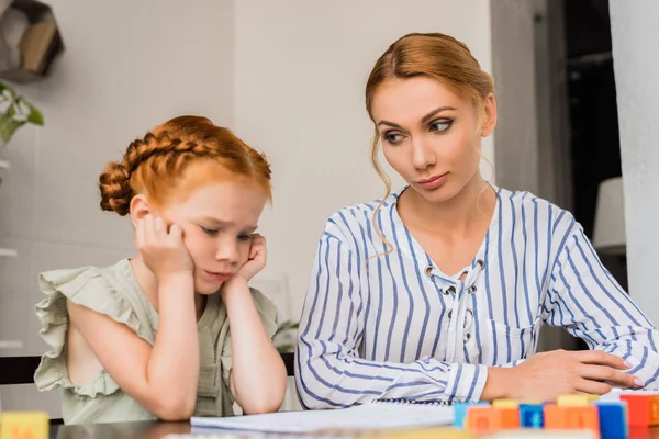 Mère regardant sceptique sur fille triste — Photo de stock