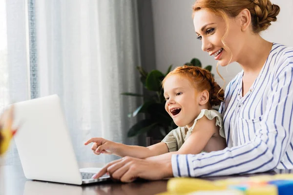 Mother and daughter using laptop — Stock Photo