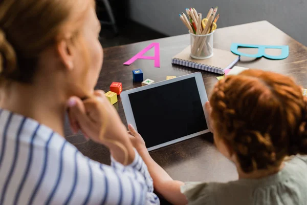 Madre e hija mirando la tableta - foto de stock