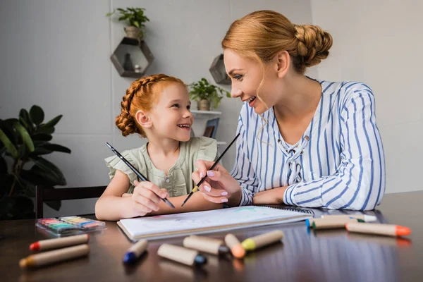 Mother and daughter drawing in album — Stock Photo
