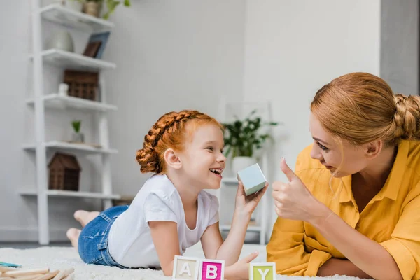Mother and daughter playing with letter cubes — Stock Photo