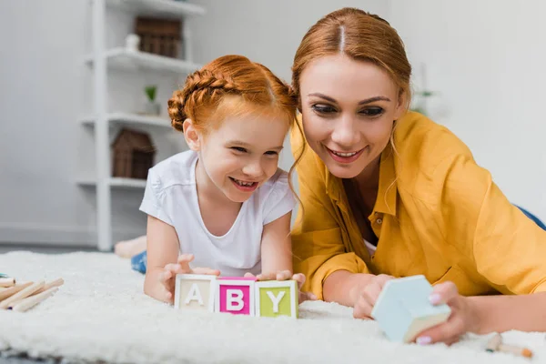 Mère et fille jouer avec des cubes de lettre — Photo de stock