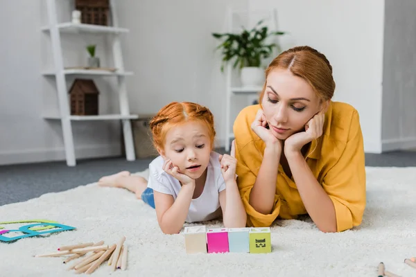 Mother and daughter playing with letter cubes — Stock Photo