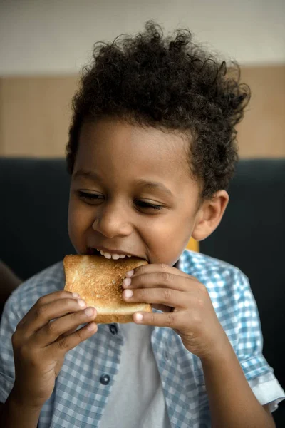 Afro-américain enfant manger pain grillé — Photo de stock