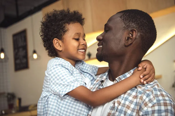 Africano americano padre y niño abrazos - foto de stock