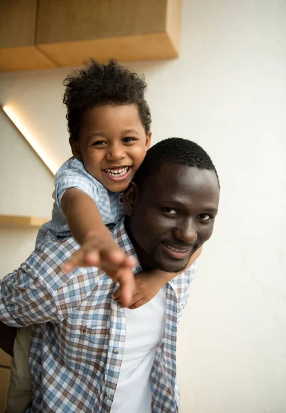Africano americano padre y niño abrazos - foto de stock