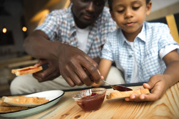 Father and son eating toasts — Stock Photo