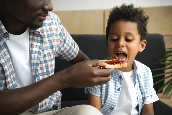 Father feeding son with toast — Stock Photo